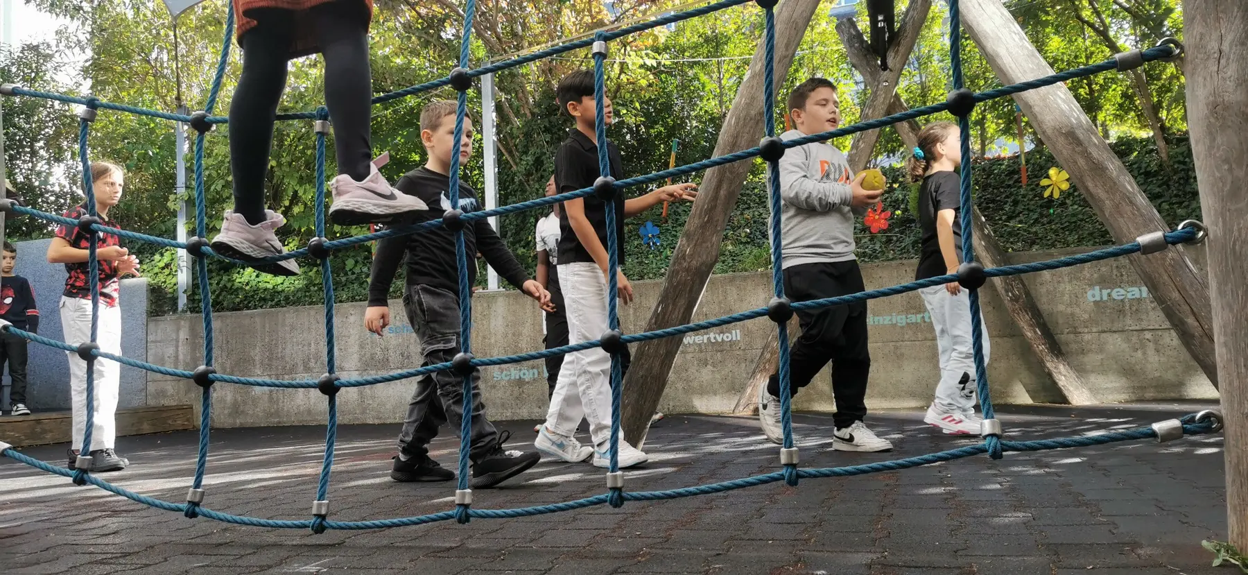 Kinder bewegen sich gemeinsam auf einem Kletterspielplatz