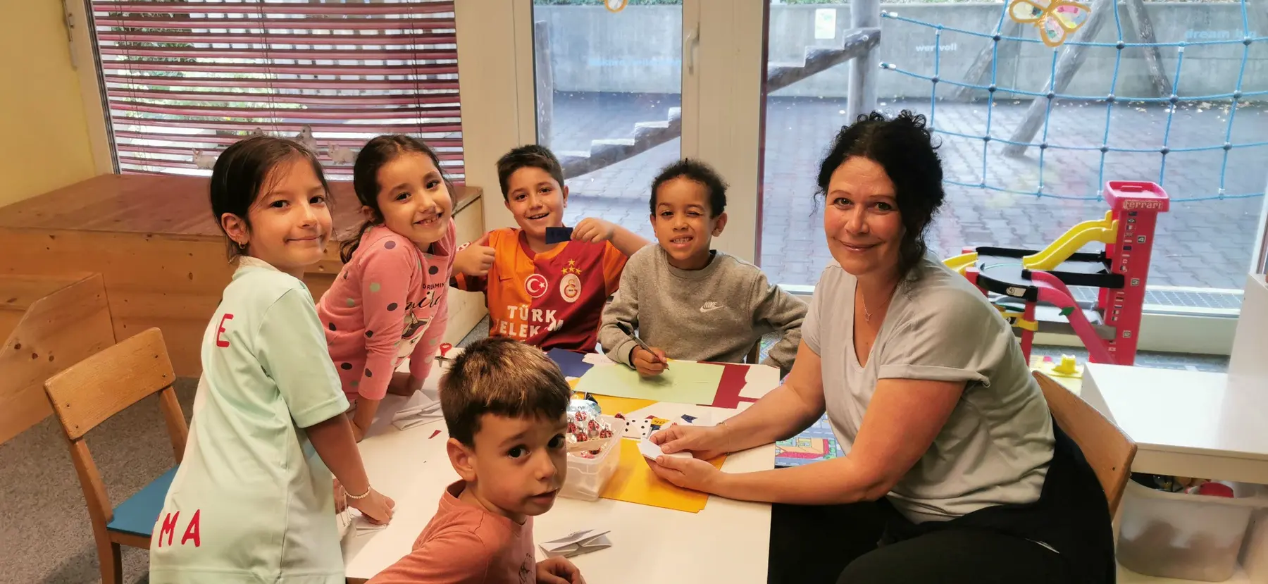 Kinder gestalten gemeinsam mit einer Mitarbeiterin der ARCHE