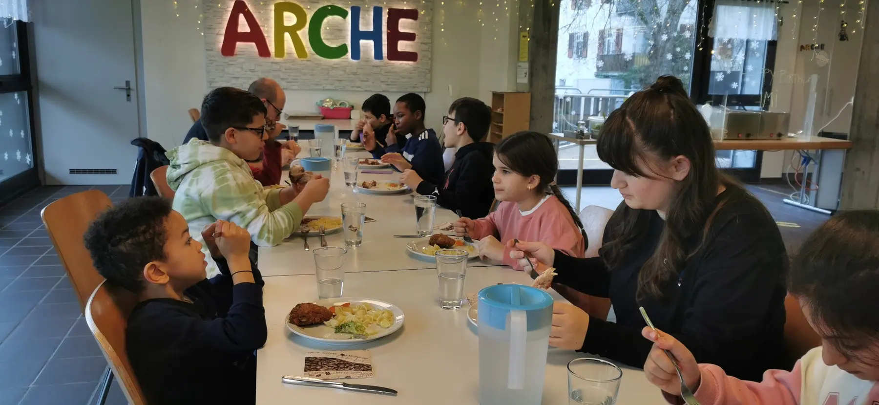 Kinder und Jugendliche essen gemeinsam am ARCHE-Mittagstisch
